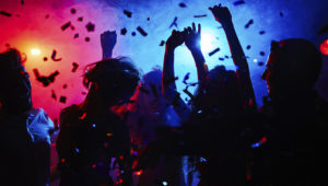 Silhouettes of dancers moving in confetti
